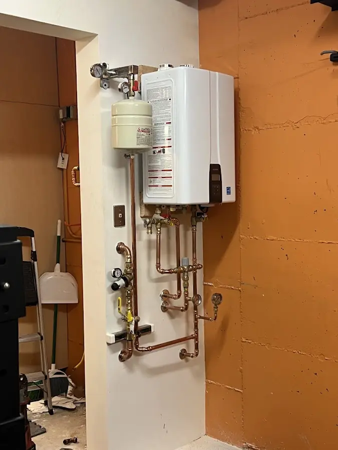Plumbing technician inspecting water heater connections in Berkeley